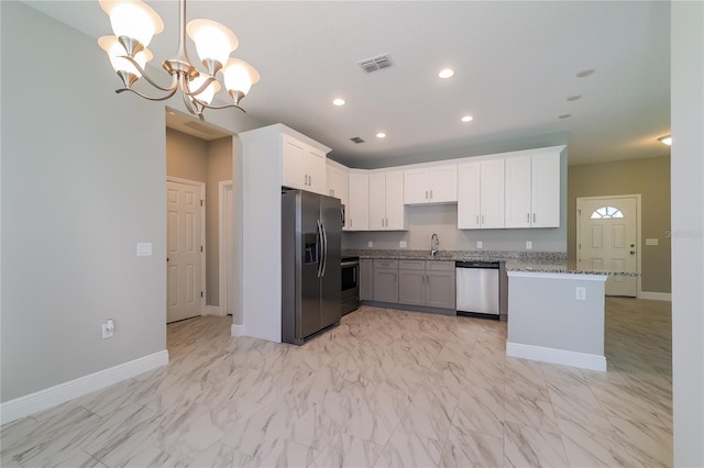 kitchen featuring appliances with stainless steel finishes, sink, decorative light fixtures, an inviting chandelier, and white cabinets