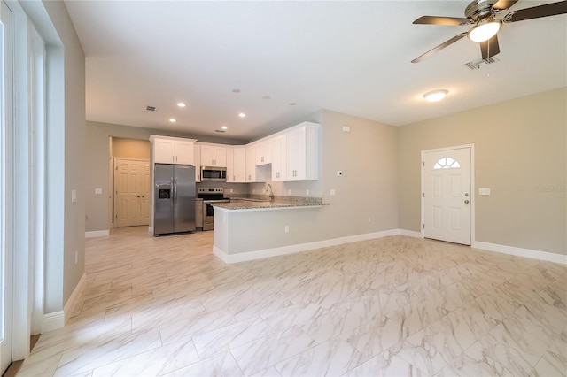 kitchen featuring white cabinetry, sink, light stone counters, kitchen peninsula, and appliances with stainless steel finishes