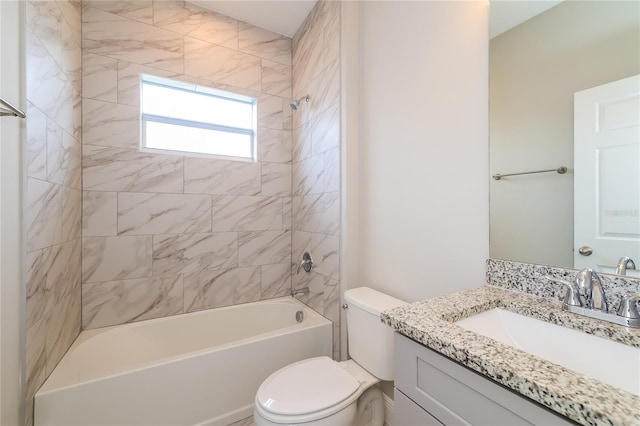 full bathroom featuring vanity, tiled shower / bath combo, and toilet