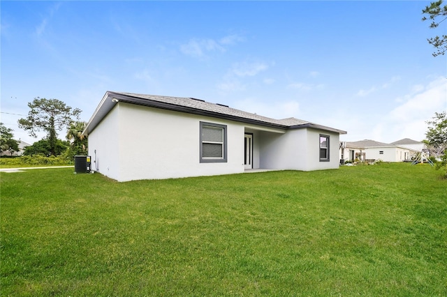 back of property featuring a lawn and central AC unit