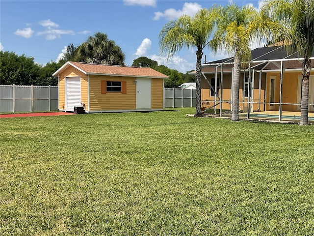 view of yard featuring a pool, glass enclosure, a storage unit, and central air condition unit