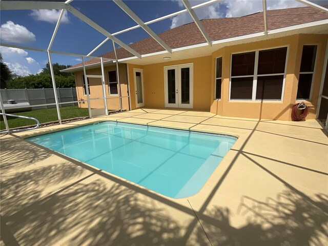 view of pool with french doors, a lanai, and a patio area