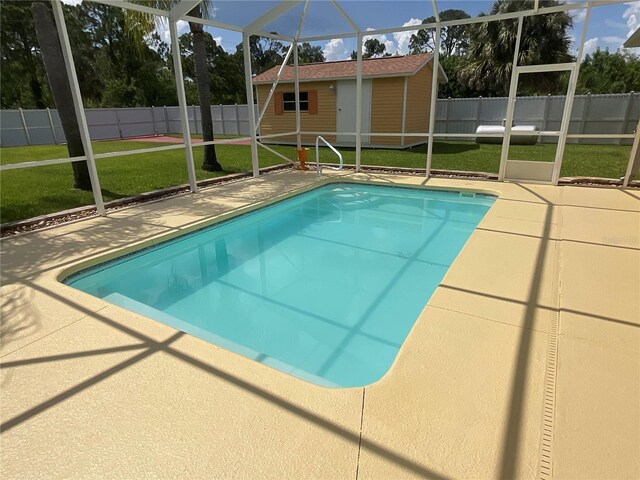 view of pool with a lanai, a storage unit, a patio area, and a lawn