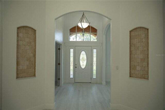 entrance foyer with a towering ceiling and light hardwood / wood-style flooring