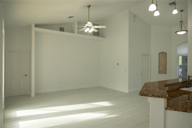 interior space with light wood-type flooring, high vaulted ceiling, ceiling fan, and sink