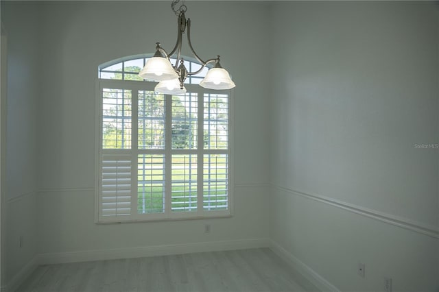 empty room featuring light hardwood / wood-style floors and an inviting chandelier