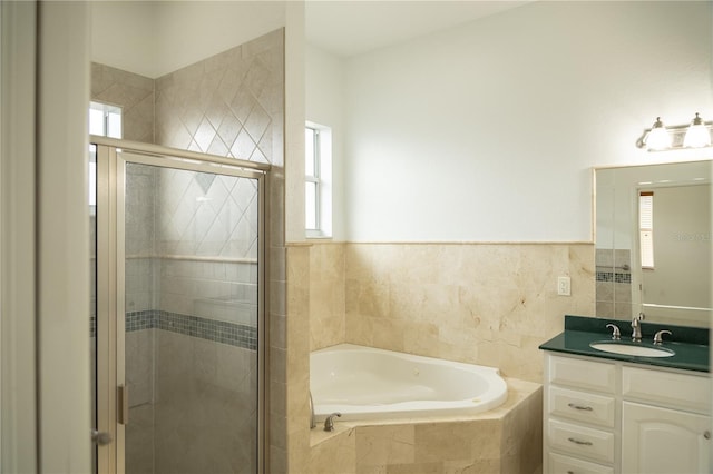 bathroom with vanity, shower with separate bathtub, and tile walls