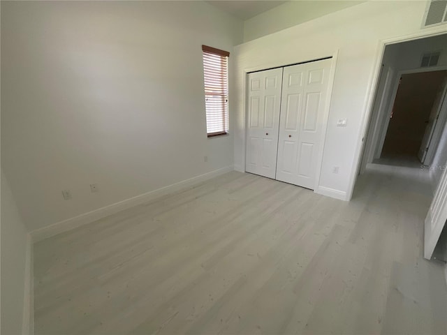 unfurnished bedroom featuring a closet and light wood-type flooring