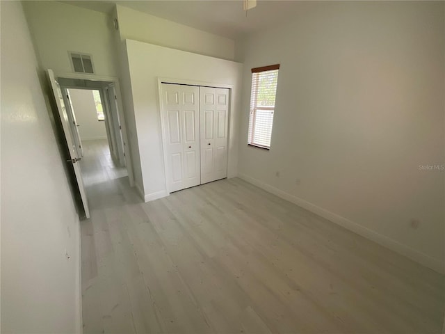 unfurnished bedroom with a closet and light hardwood / wood-style flooring