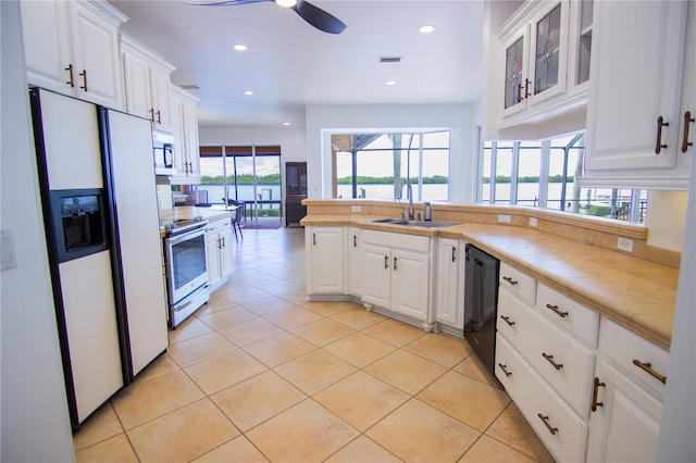 kitchen featuring light tile patterned floors, stainless steel appliances, sink, and white cabinets