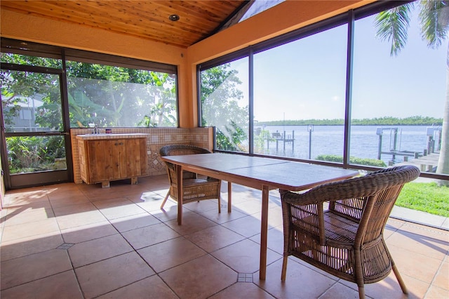 sunroom / solarium with vaulted ceiling, wooden ceiling, and a water view