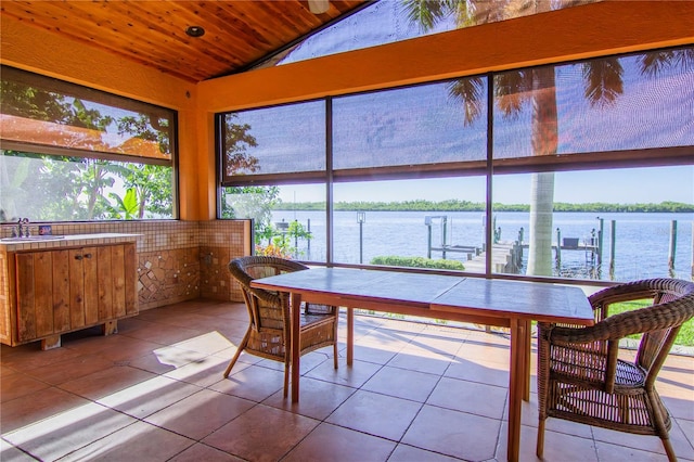 sunroom / solarium with a water view, lofted ceiling, wood ceiling, and plenty of natural light