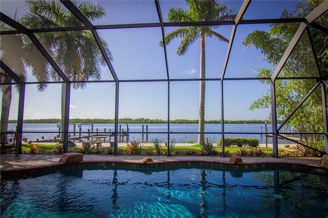 view of swimming pool featuring a water view, a patio area, and glass enclosure