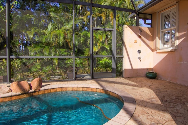 view of pool with a patio and glass enclosure