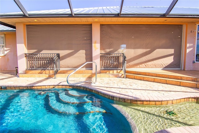 view of swimming pool featuring glass enclosure