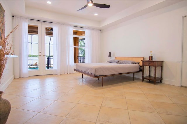 bedroom with french doors, a raised ceiling, light tile patterned floors, and access to outside