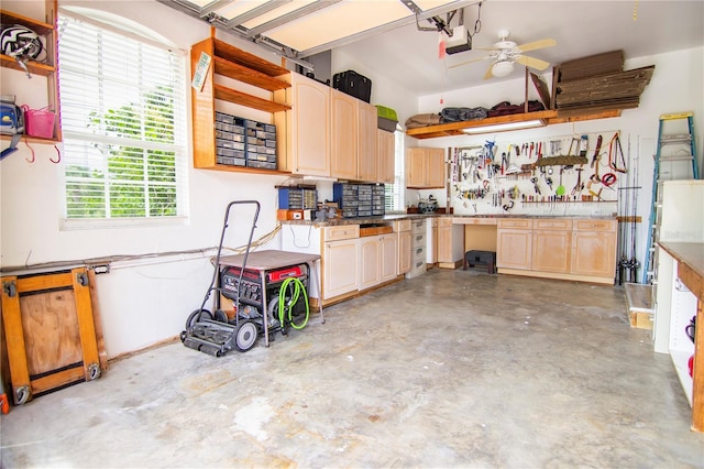 garage featuring a garage door opener, ceiling fan, and a workshop area