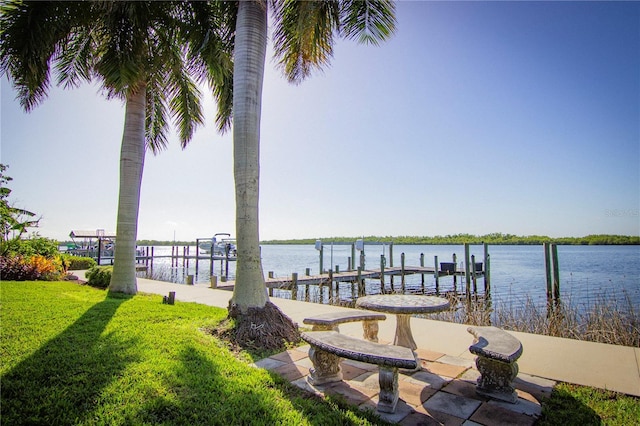 view of dock featuring a lawn and a water view