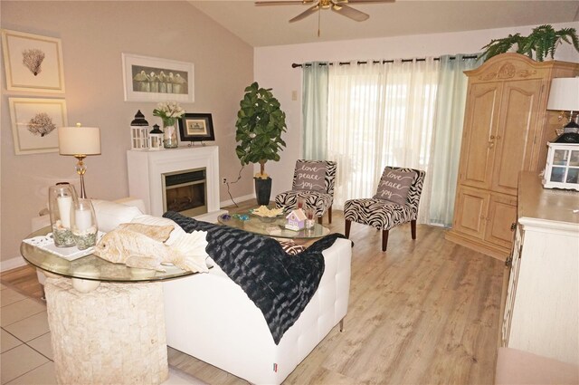 living room featuring ceiling fan, light hardwood / wood-style flooring, and lofted ceiling