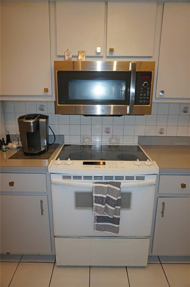 kitchen with backsplash, gray cabinets, electric range, and light tile patterned floors