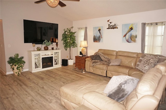 living room with hardwood / wood-style flooring, ceiling fan, and lofted ceiling