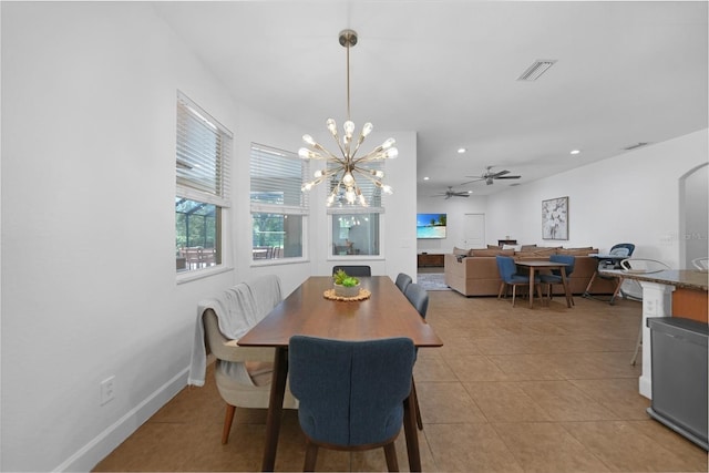 tiled dining room featuring ceiling fan with notable chandelier