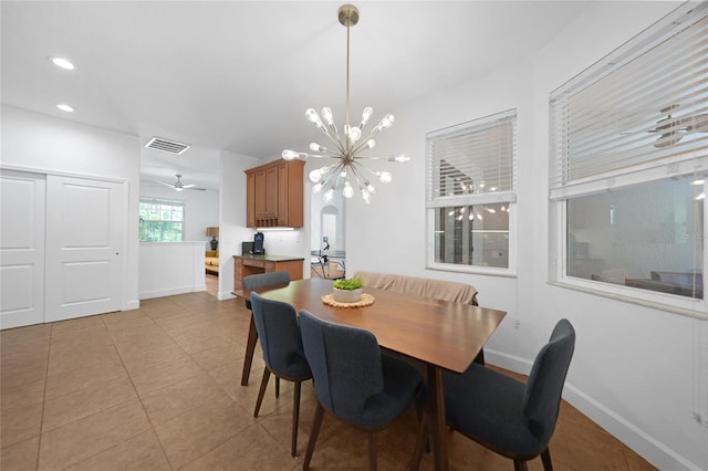 dining space with light tile patterned floors and ceiling fan with notable chandelier