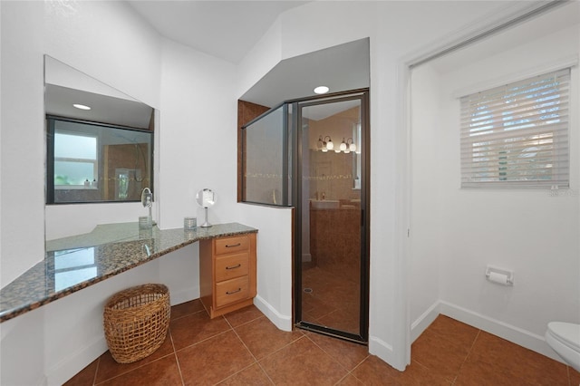 bathroom featuring tile patterned flooring, toilet, and a shower with door