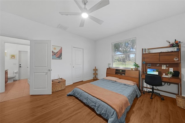 bedroom featuring light wood-type flooring, ensuite bath, and ceiling fan