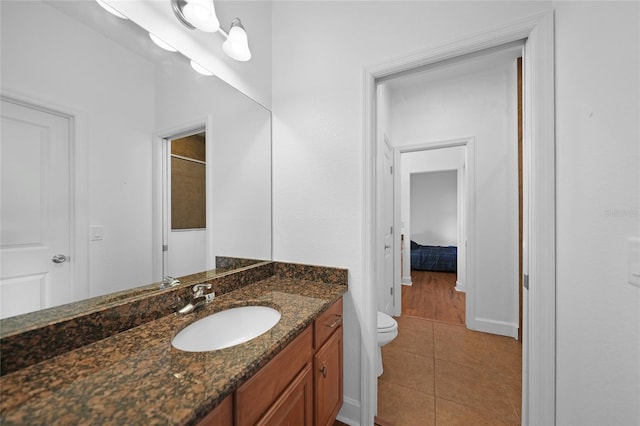 bathroom with tile patterned flooring, vanity, and toilet