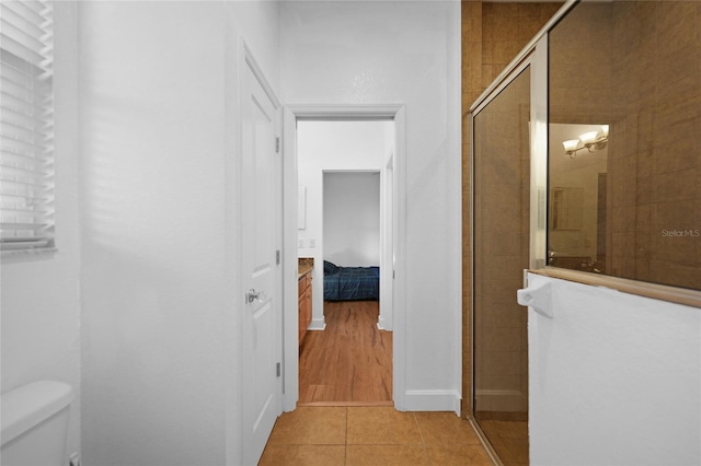 bathroom with tile patterned floors, toilet, and walk in shower