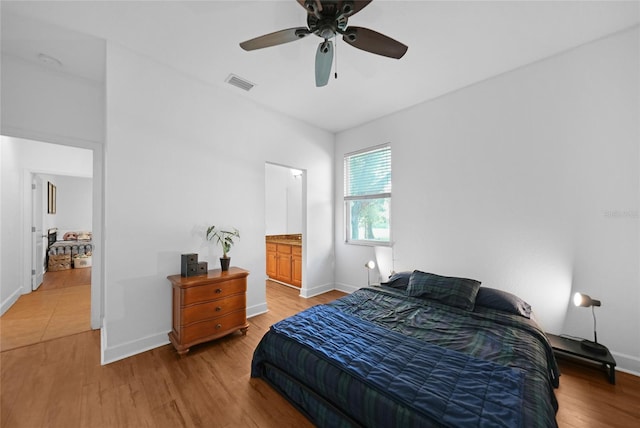 bedroom with connected bathroom, ceiling fan, and light hardwood / wood-style floors