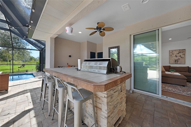 view of patio featuring a lanai, ceiling fan, and an outdoor bar