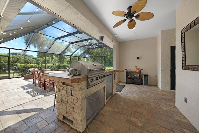 view of patio / terrace with grilling area, ceiling fan, a lanai, area for grilling, and a bar