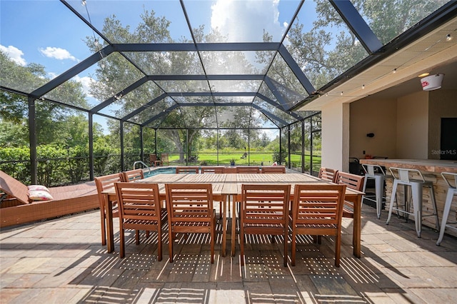 view of patio featuring a bar and a lanai