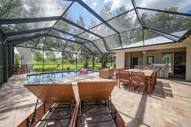 view of patio / terrace with ceiling fan, exterior bar, and glass enclosure