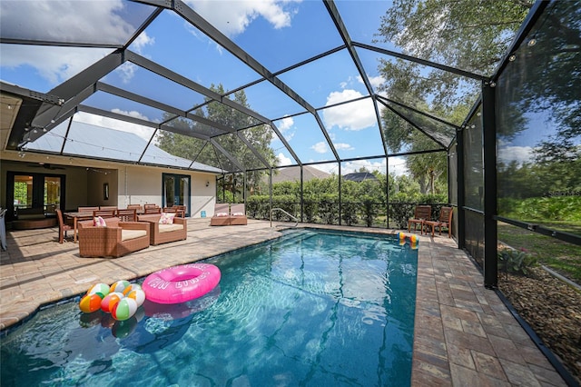 view of pool with a lanai, an outdoor living space, french doors, and a patio