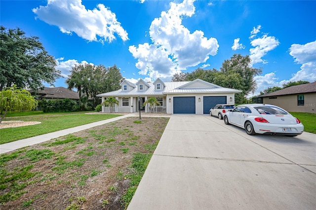 view of front of house featuring covered porch, a garage, and a front yard