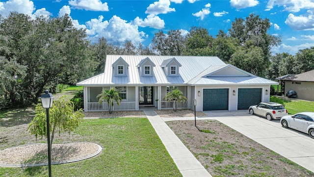 view of front of house with a garage, covered porch, and a front lawn