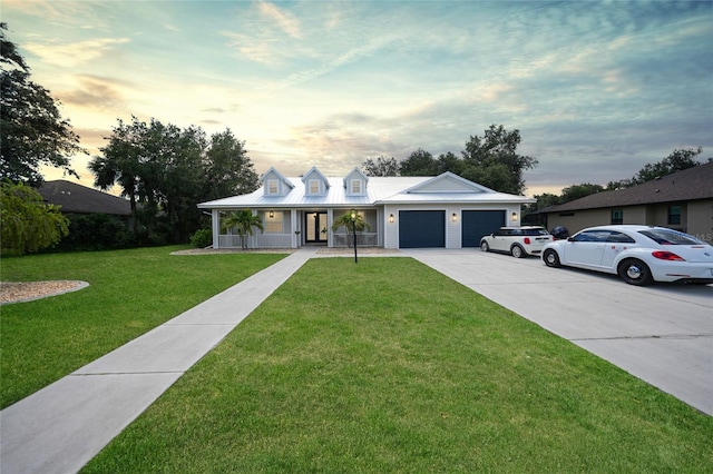 view of front facade with a lawn, a porch, and a garage