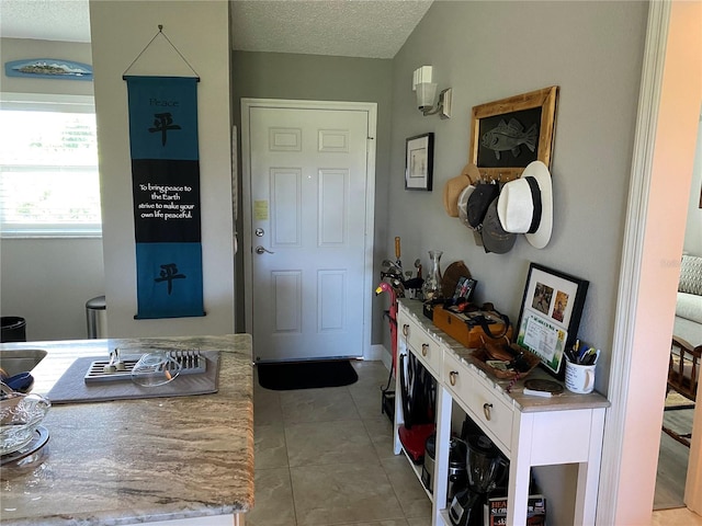 tiled foyer entrance with a textured ceiling