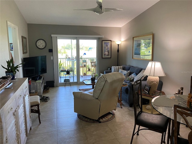 living room featuring lofted ceiling, light tile patterned floors, and ceiling fan