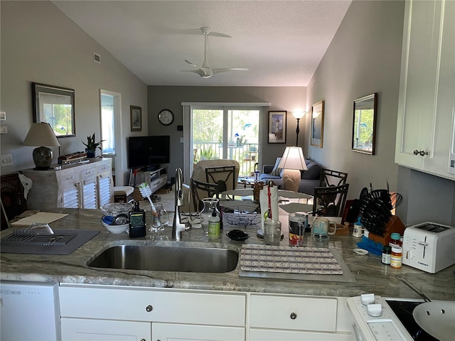 kitchen with lofted ceiling, white cabinets, dishwasher, ceiling fan, and sink