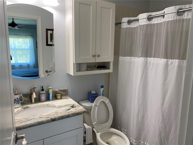 bathroom with toilet, vanity, and ceiling fan