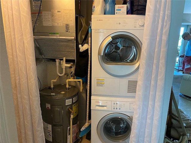 laundry area with electric water heater and stacked washer and clothes dryer