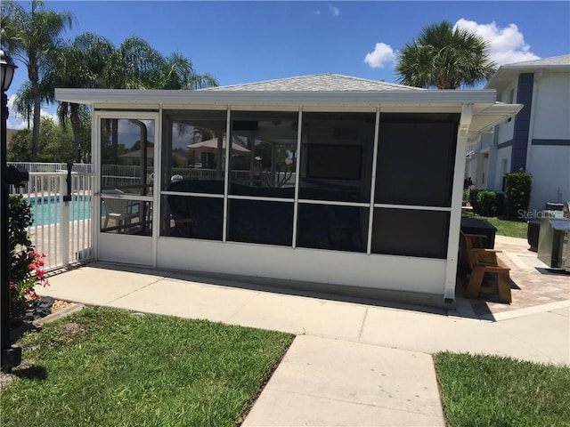 rear view of property featuring a sunroom