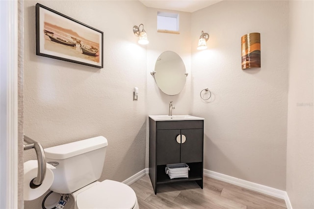 bathroom featuring toilet, vanity, and hardwood / wood-style flooring