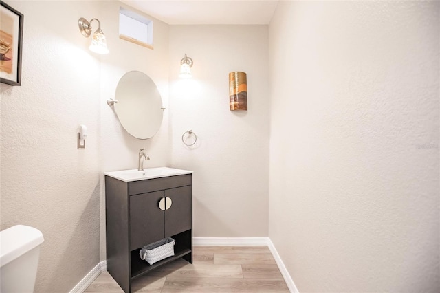 bathroom featuring wood-type flooring, vanity, and toilet