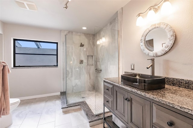 bathroom featuring vanity, toilet, and walk in shower