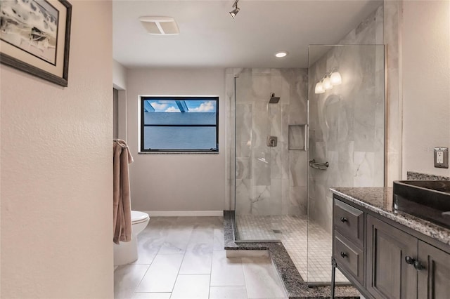 bathroom with a shower with door, vanity, and toilet